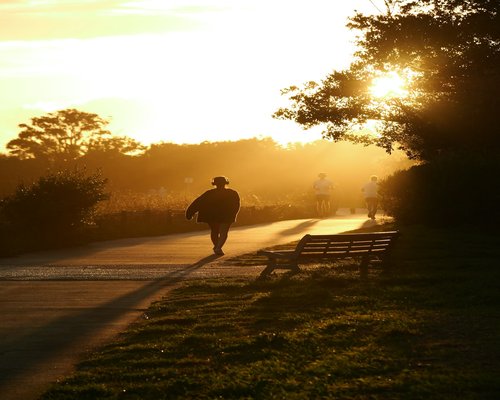 Man running outdoors at sunset in a city park
